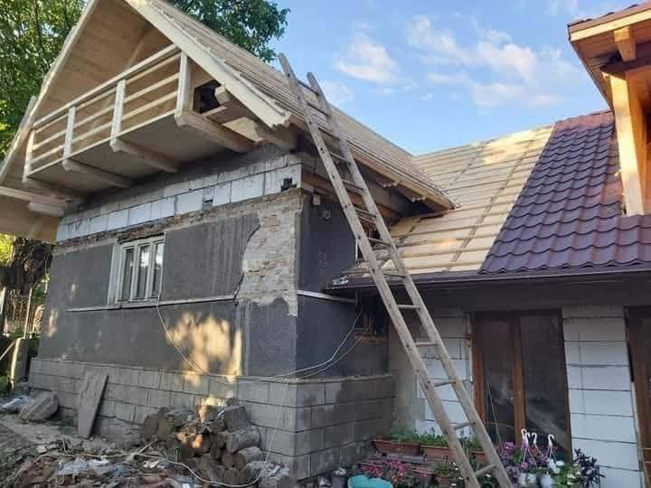 Casă cu schelă și scară în timpul renovării acoperișului lângă Cluj